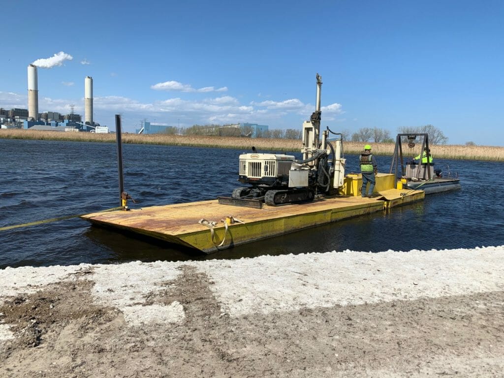 small barge on water performing pond sediment sampling, direct push method, environmental drilling